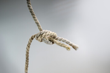 Two ropes are tied together in a knot, business concept for teamwork and cooperation, gray background, copy space - 777745529
