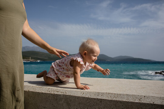 Baby girl crawling by the adriatic sea
