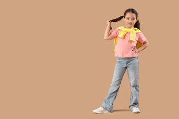 Portrait of fashionable little girl on beige background