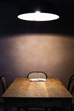 Blank notebook on a rustic table under a pendant lamp