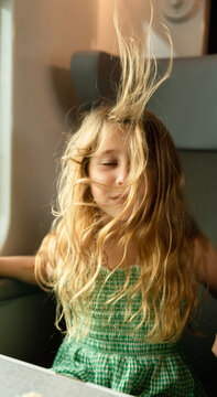 A little girl blowing her hair up
