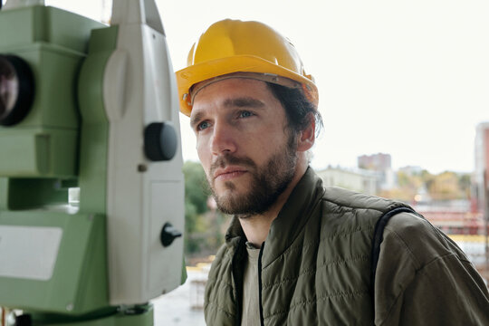 Construction Worker In Hardhat Using Theodolite