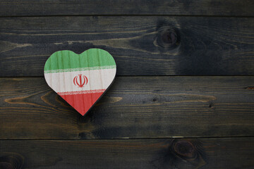 wooden heart with national flag of iran on the wooden background.