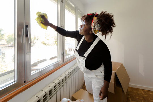 Women cleaning new home and unpacking while moving in