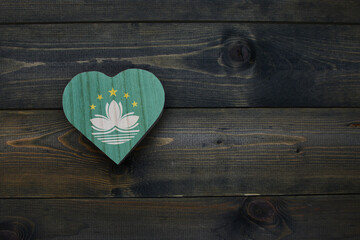 wooden heart with national flag of Macau on the wooden background.