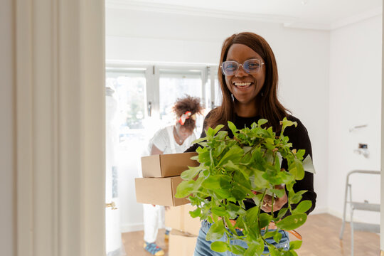 Woman carrying stuff moving out smiling at camera