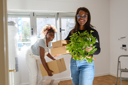 Woman carrying stuff moving out smiling at camera