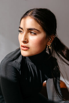 Young sensual female model with makeup looking away in studio