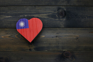 wooden heart with national flag of taiwan on the wooden background.