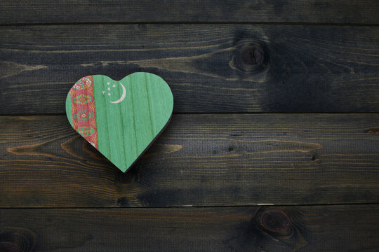 wooden heart with national flag of turkmenistan on the wooden background.