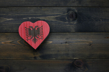 wooden heart with national flag of albania on the wooden background.