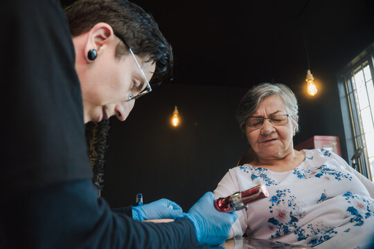 Senior woman getting a tattoo
