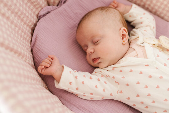 Sleeping newborn girl lying in cradle