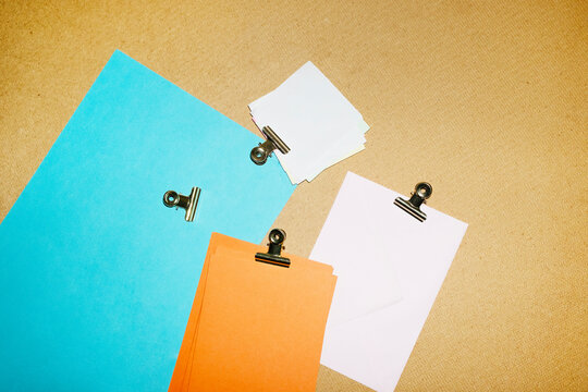 Colourful papers and post-it with golden clips in a work office