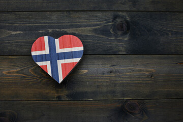 wooden heart with national flag of norway on the wooden background.