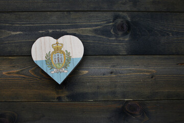 wooden heart with national flag of san marino on the wooden background.