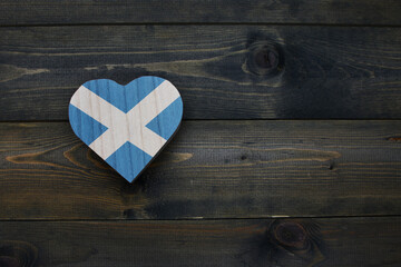 wooden heart with national flag of scotland on the wooden background.