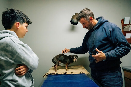 Father and his son saying goodbye to the family dog. 