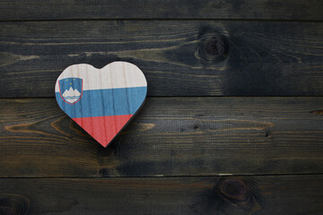 wooden heart with national flag of slovenia on the wooden background.