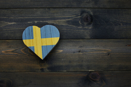 wooden heart with national flag of sweden on the wooden background. - Powered by Adobe