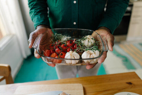 A man with vegetables from an oven