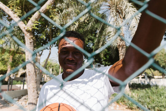 A man with a basketball standing by the net