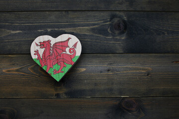 wooden heart with national flag of wales on the wooden background.