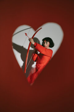 Female in red clothing holding bow and arrow 