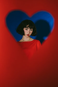 Portrait of a person Looking Though A Red Heart Shape