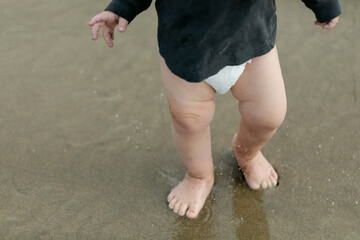 Closeup of a Baby's Legs as they Walk Barefoot on the Beach