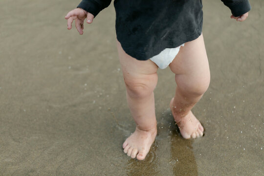 Closeup of a Baby's Legs as they Walk Barefoot on the Beach