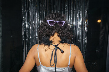 closeup of woman standing back to the camera with sunglasses on head