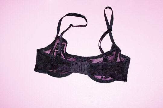 Black transparent mesh bra / lingerielaying on pink background