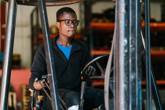 Black male forklift truck operator working at factory