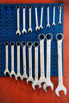 Different sized wrenches hanging on wall