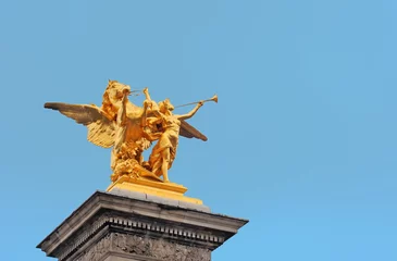 Photo sur Plexiglas Pont Alexandre III Golden statue with winged horse and female musician at the Alexander III bridge in  Paris, France with clear blue sky