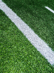 Football Field Turf. Bright green turf football field surface with white yard line markings. Angled...