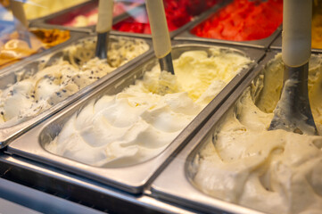 Assortment of fresh made Italian artisanal ice creams in refrigerator close up, walnuts dessert,...