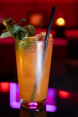 Whiskey and rum colorful cocktails served with ice cubes on black table in dark cocktail bar in Italy