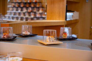 Japanese cuisine, modern restaurant with sushi, sashimi, other Japanese dishes served on moving belt across restaurant, self-service lunch cafe