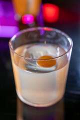 Whiskey and rum colorful cocktails served with ice cubes on black table in dark cocktail bar in Italy