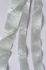 silver crepe paper streamer or stripes on blank paper with texture