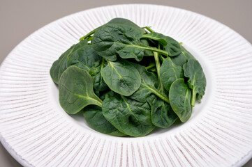 Fresh green baby Spinach leaves, diet and health concept, weight loss, spinach on ceramic plate,...