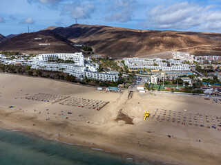 White sandy beach and blue ocean water in Morro Jable vacation village on south of Fuerteventura, Canary islands, Spain