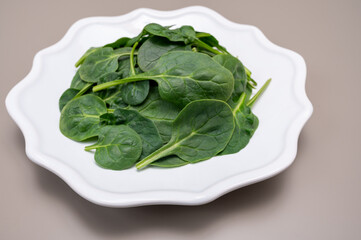 Fresh green baby Spinach leaves, diet and health concept, weight loss, spinach on ceramic plate,...
