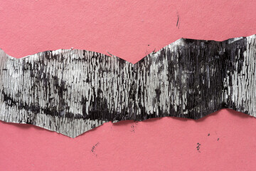 grungy crepe paper with metallic silver finish stained with black ink on rough pink toned...