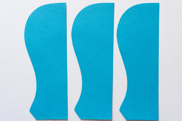 three blue paper shapes with elegant curve or wavy edge and a hard geometric side on blank paper...