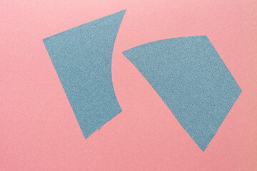 two shapes composed of vinyl with glitter on old pink construction paper