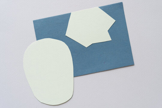 two abstract paper shape (roundish and starish) on blue card and blank paper