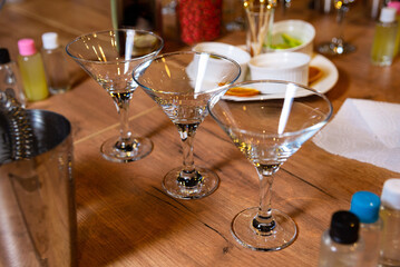 Elegant Martini Glasses on a Wooden Bar Counter. Empty martini glasses await a mixologist's craft...